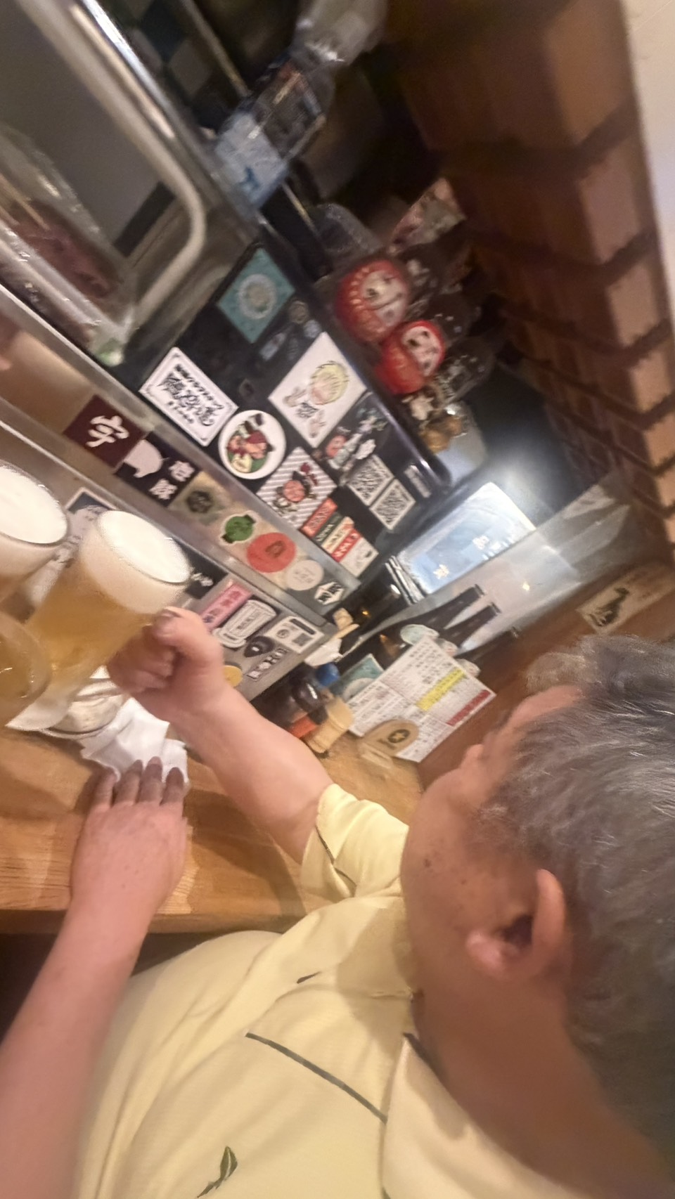 お香芽のカウンターでビールを前に語り合う様子